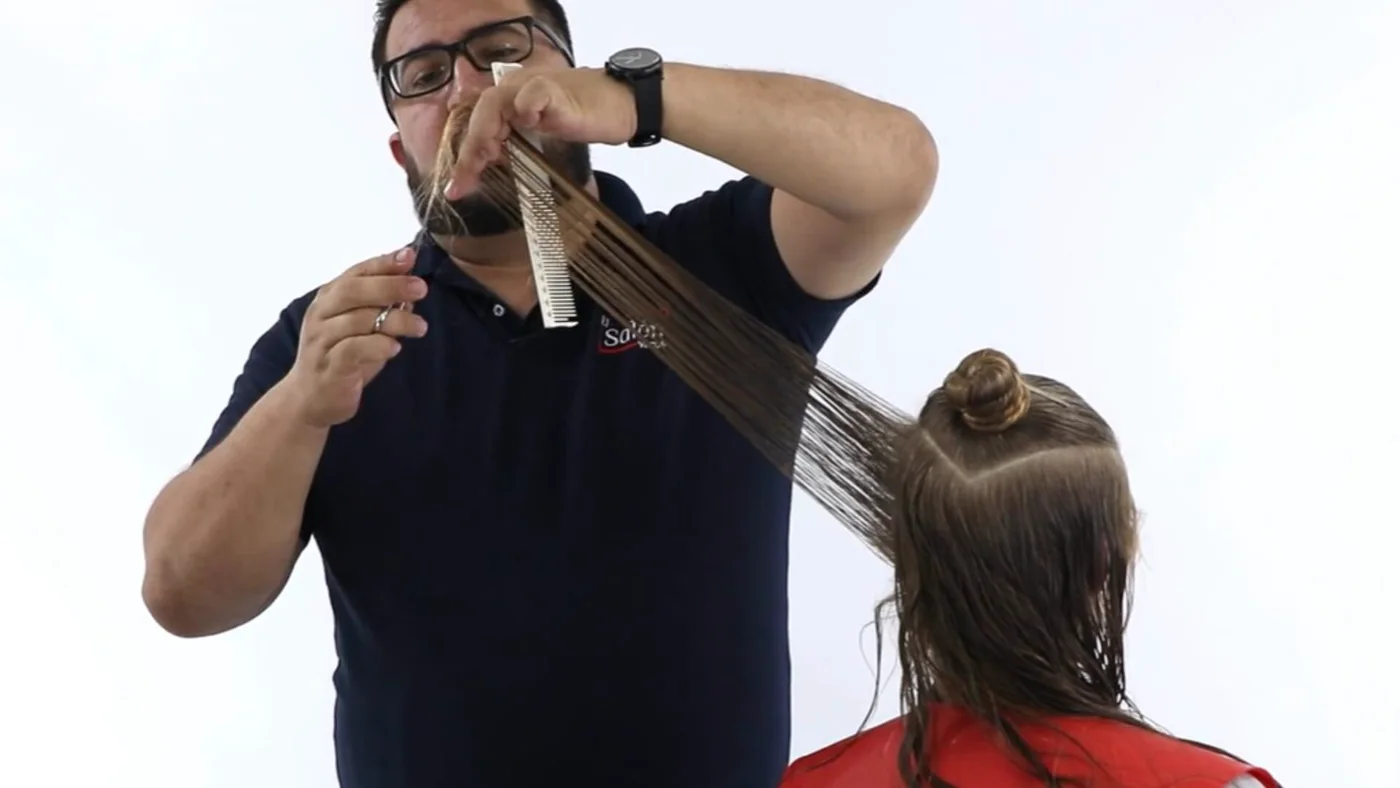 Estilista haciendo un corte en capas con tijera