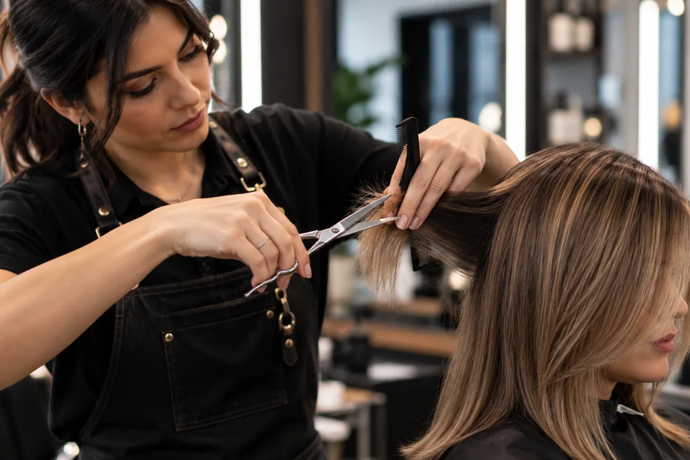 Estilista haciendo un corte profesional en el salón